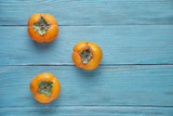 Delicious fresh persimmon on a wooden background. View from above.