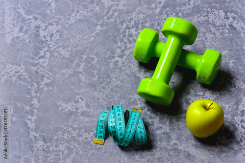 Dumbbells in green color, apple and cyan measuring tape