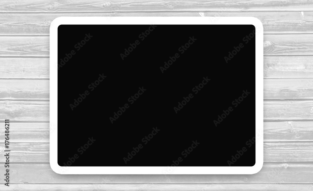 Tablet with the dark screen on wooden background. White frame with a black background on a wooden Board with copy space for your text. Tablet with the dark screen on wooden background. White frame with a black background on a wooden Board with copy space for your text.
