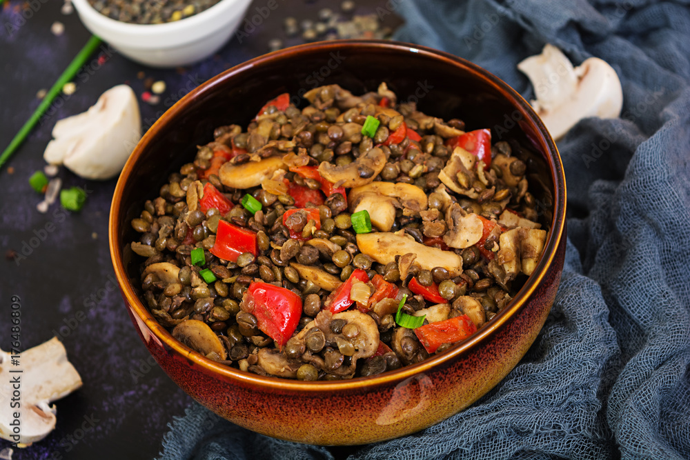 Delicious lentils with pepper and mushrooms on dark background Delicious lentils with pepper and mushrooms on dark background