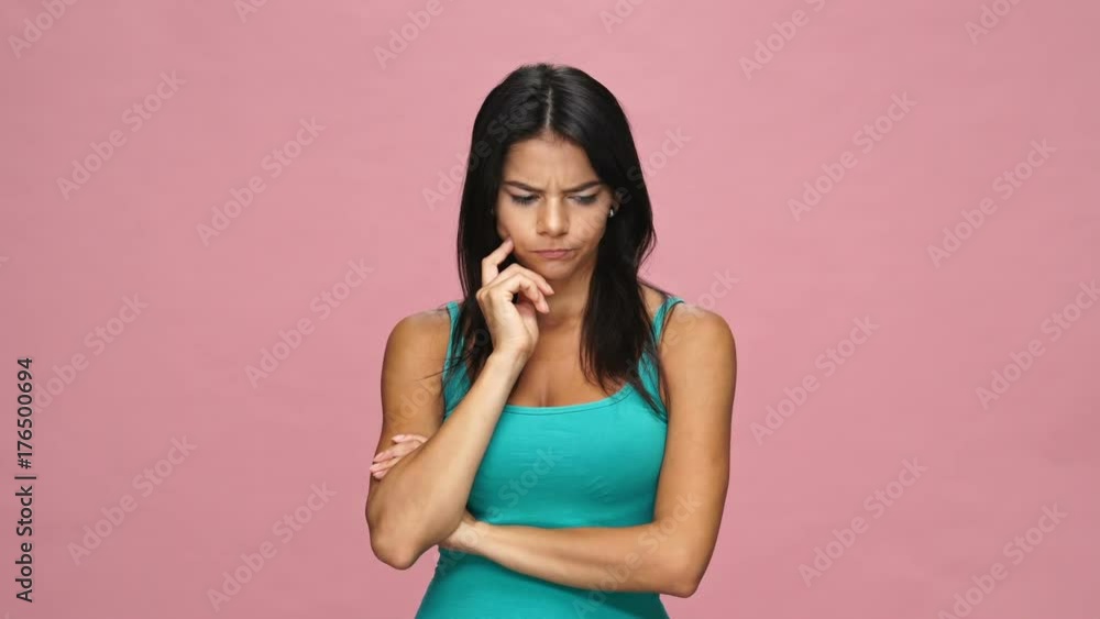 Pensive pretty brunette woman thinking and having an idea isolated over pink Pensive pretty brunette woman thinking and having an idea isolated over pink