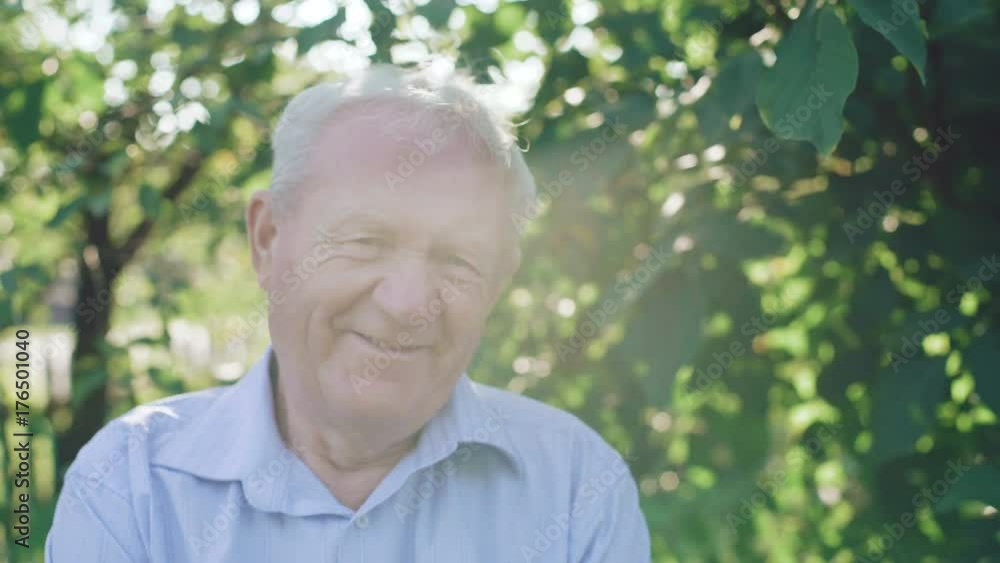 Portrait of lonely senior smiling at camera in the garden. 4K Portrait of lonely senior smiling at camera in the garden. 4K