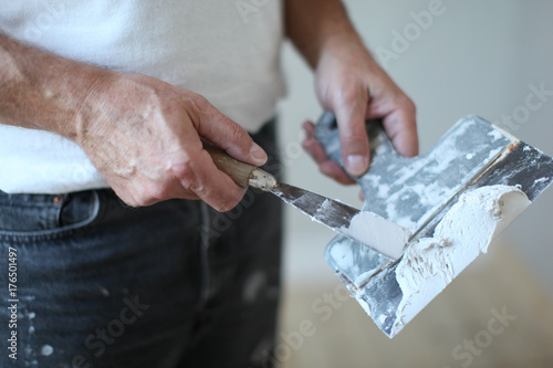 handyman at work, working with sand plaster filler on stopping knife , house painter photo