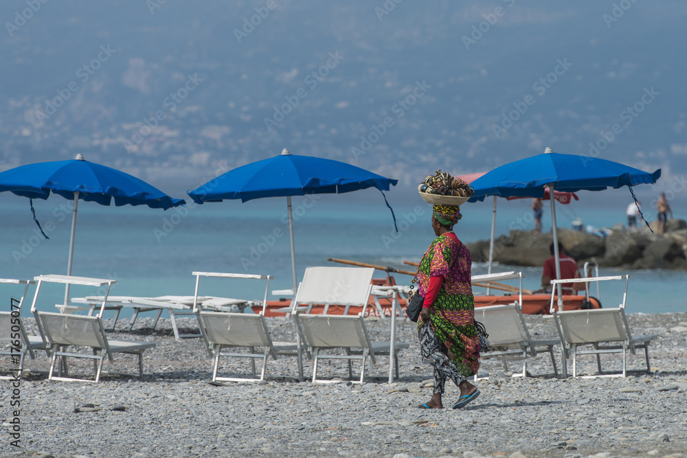 Fotografie Italy,Liguria, peddler on the beach.
