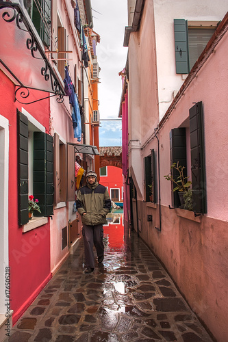 Tourist walking in the colorful street of Burano island  Venice  Italy