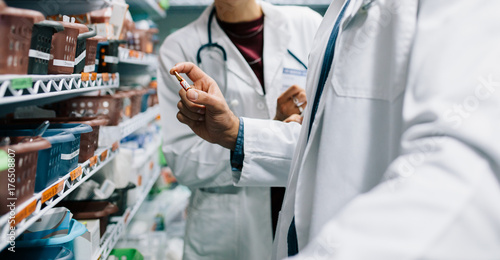 Принти на полотні Two pharmacist looking for critical medicinal drug