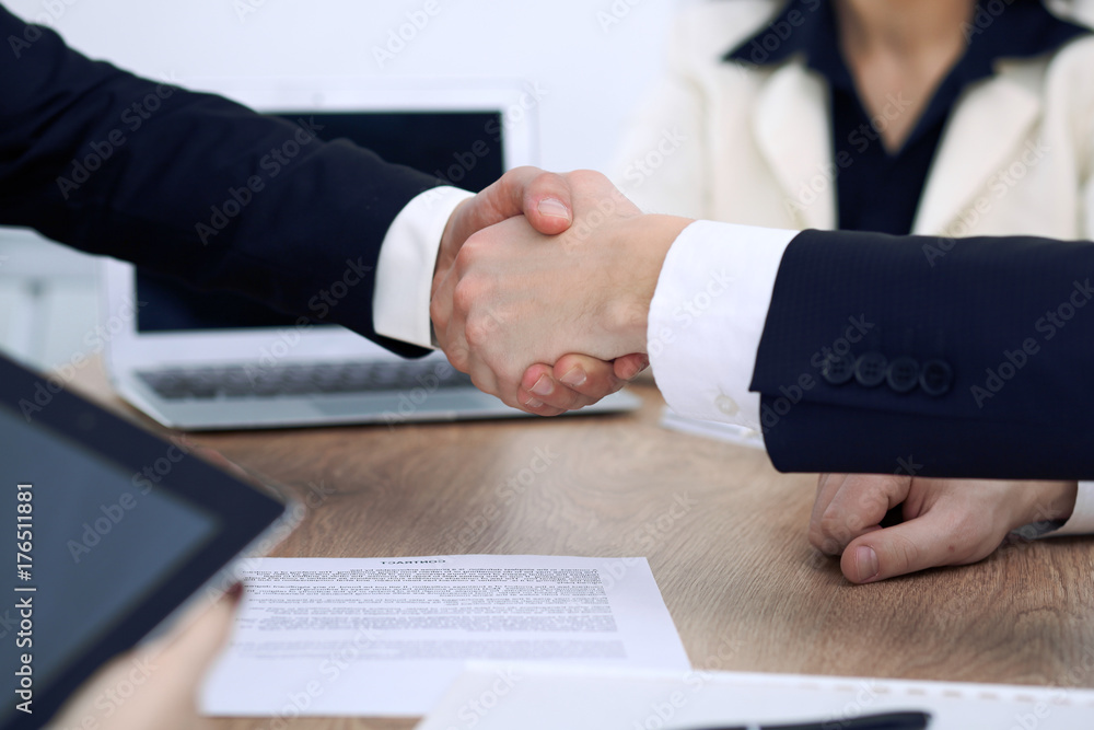 Close up of business people shaking hands at meeting or negotiation in the office. Partners are satisfied because signing contract Close up of business people shaking hands at meeting or negotiation in the office. Partners are satisfied because signing contract