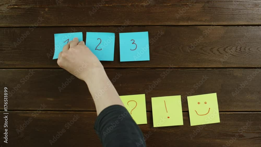 Top down shot of sticky notes of different colors on wooden desk Top down shot of sticky notes of different colors on wooden desk