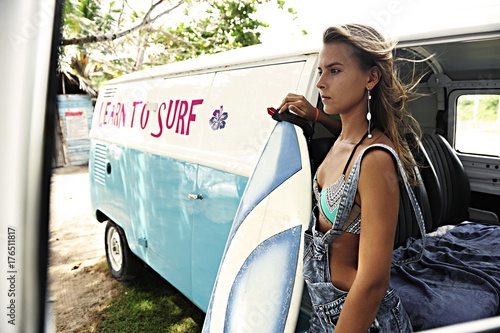 Portrait of woman with surfboard at van photo