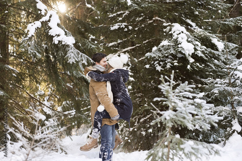 Happy young couple face to face in snow-covered winter forest