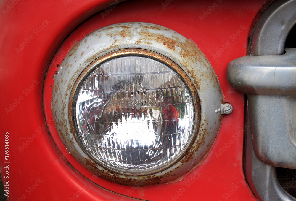 Detail of the front headlight of an old car.