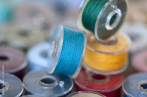 Close-up on colored sewing threads on spools