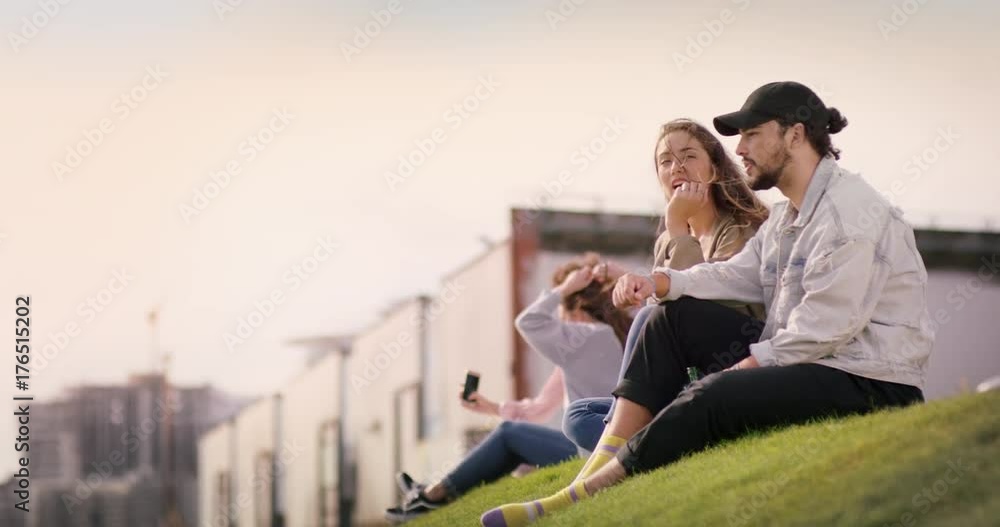 Group of young people on a meadow while one Girl is pointing a Finger at something Group of young people on a meadow while one Girl is pointing a Finger at something