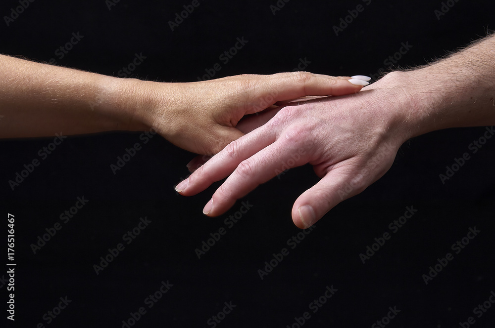Male and female hands together on black background