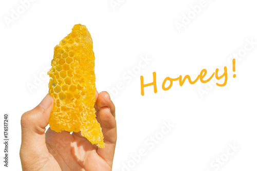 Yellow honeycomb with sweet honey in the woman's hand with inscription HONEY on the blue background