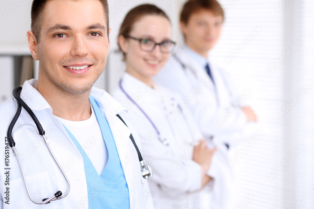 Cheerful smiling male doctor with medical staff at the hospital Cheerful smiling male doctor with medical staff at the hospital