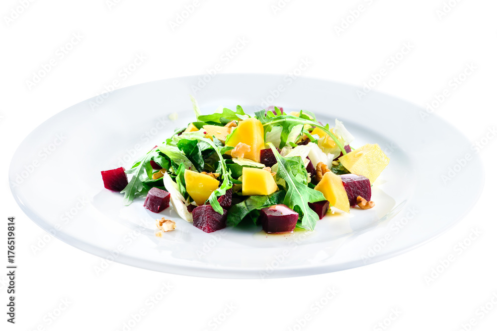 Delicious and appetizing salad with beetroot and fruit mango in a white plate isolated on white background. Autumn menu in an Italian restaurant. Photo for menu design