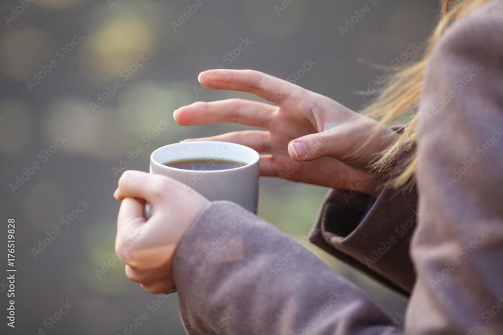 Close up of woman drinking from a cup against autumn leaves pattern Close up of woman drinking from a cup against autumn leaves pattern