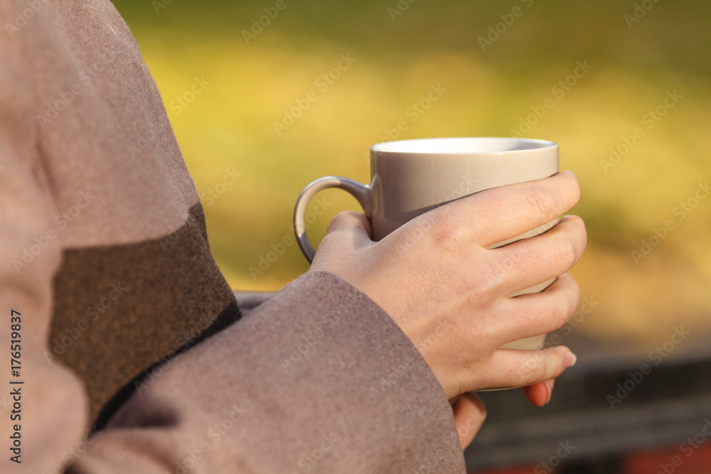 Close up of woman drinking from a cup against autumn leaves pattern Close up of woman drinking from a cup against autumn leaves pattern