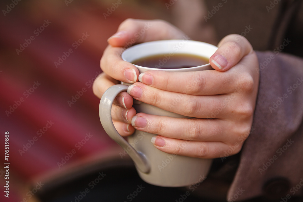 Girl in jacket sitting on the bench, holding a coffee or tea, a young outdoors, spring or fall, life style, the concept of the city, lifestyle Girl in jacket sitting on the bench, holding a coffee or tea, a young outdoors, spring or fall, life style, the concept of the city, lifestyle