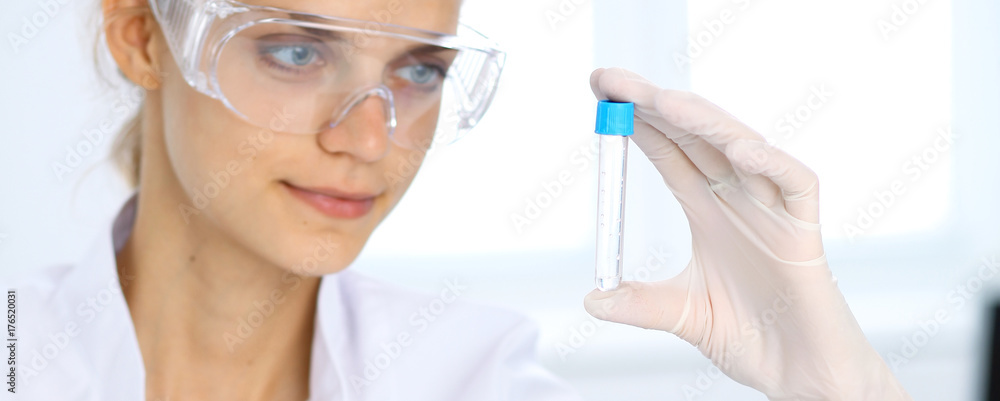 Female scientific researcher in laboratory studying substances or blood sample. Medicine and science concept Female scientific researcher in laboratory studying substances or blood sample. Medicine and science concept