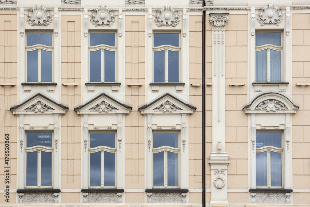 Obraz premium Eight Windows on the facade of the old vintage beige house