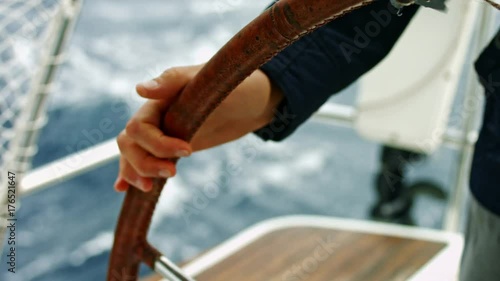 Man holding steering wheel. Controlling a yacht