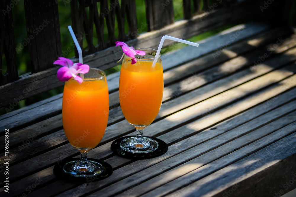 Fototapeta Orange juice on wooden chair