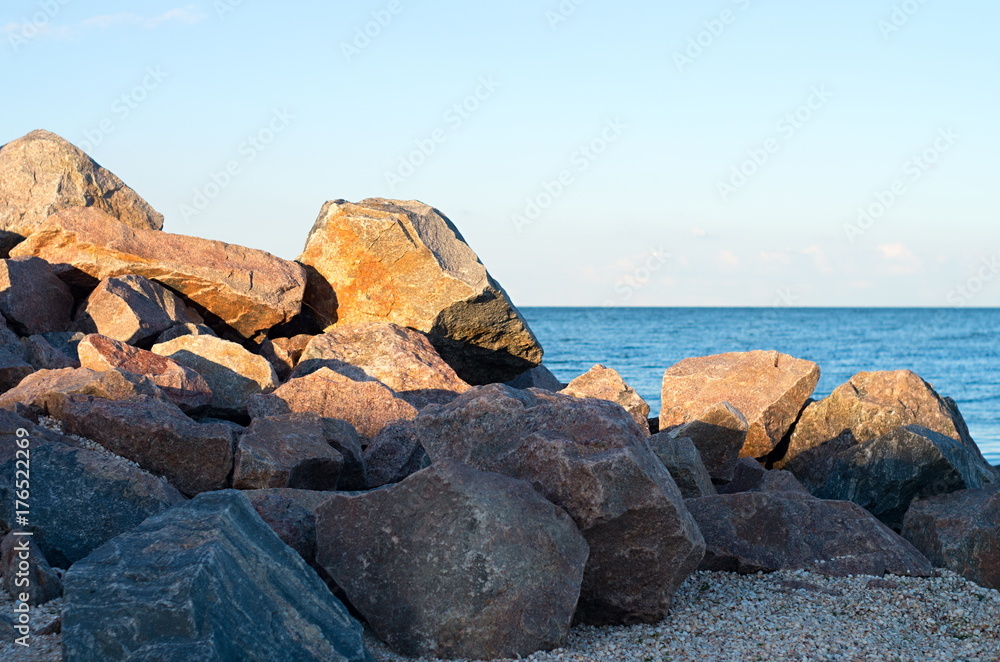 stone beach on the sea shore. blue sky horizon.