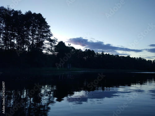 Lake surface at evening in Latvia, East Europe. Landscape with water and forest.