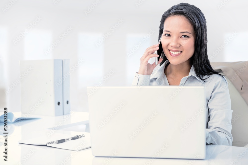 Composite image of smiling businesswoman phoning at the desk Composite image of smiling businesswoman phoning at the desk
