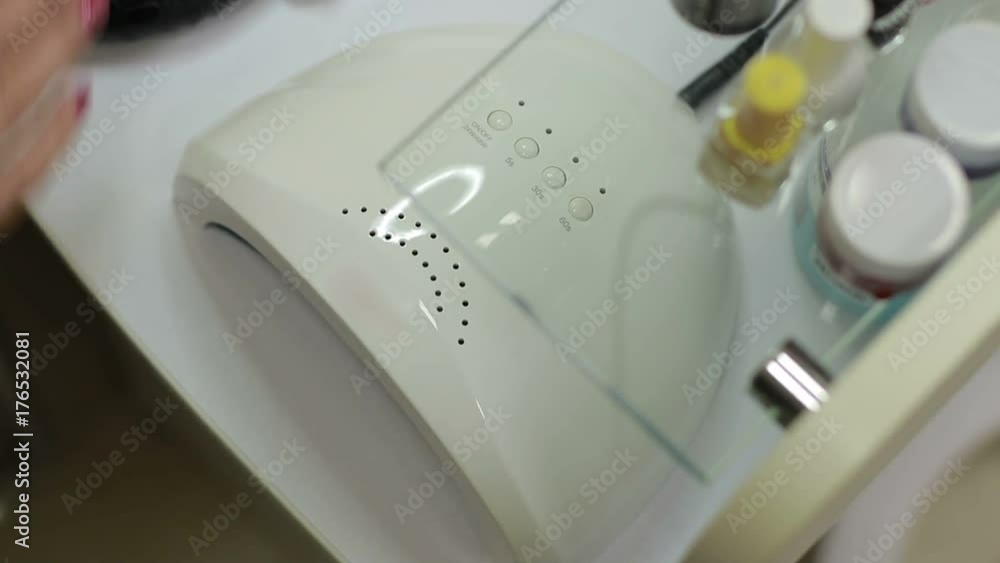 Client drying gel polished nails in UV light Client drying gel polished nails in UV light