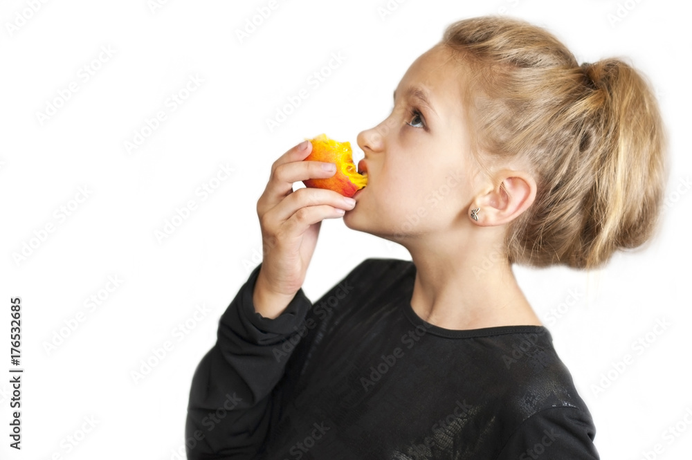 The blonde girl eats a delicious peach and looks upstairs The blonde girl eats a delicious peach and looks upstairs