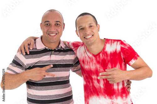 Two Latin American friends pose for the photo. They gesture with the hand and form the letter V. White background.. photo