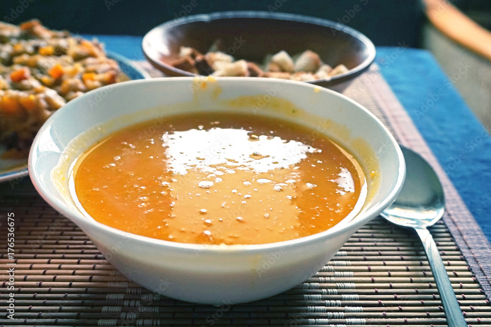 White dish with pumpkin soup-puree close-up. Selective focus. White dish with pumpkin soup-puree close-up. Selective focus.