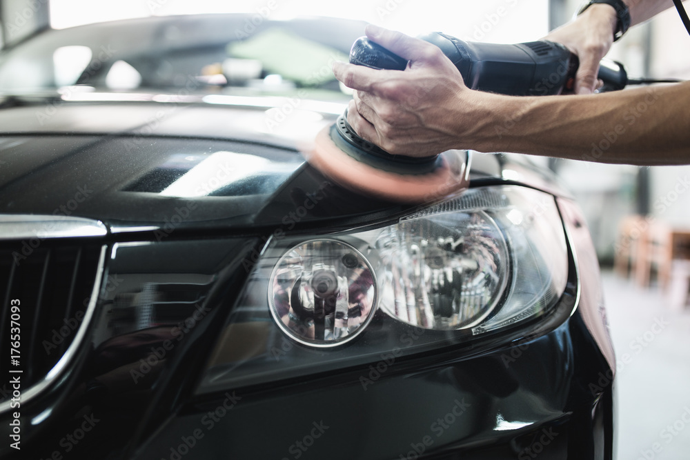 Car detailing - Hands with orbital polisher in auto repair shop. Selective focus. Car detailing - Hands with orbital polisher in auto repair shop. Selective focus.