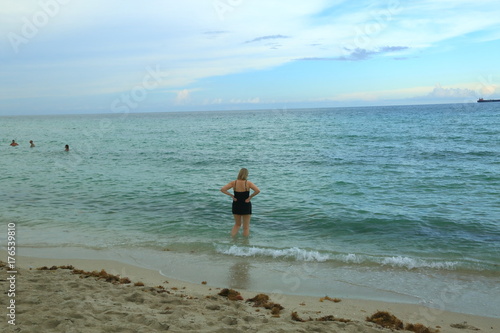 View of woman standing in Atlantic ocean and going to swim