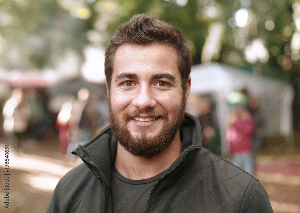 Fototapeta premium junger Mann mit Vollbart auf Markt, Hipster lächelnd