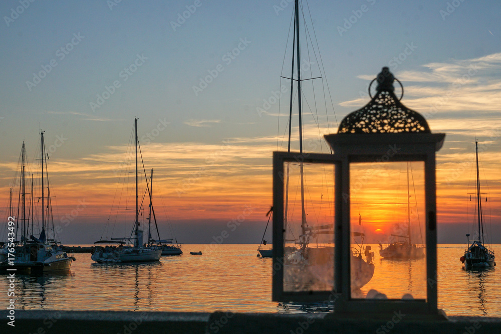 untergehende Sonne im Hafen von Novigrad, durch die Laterne gesehen