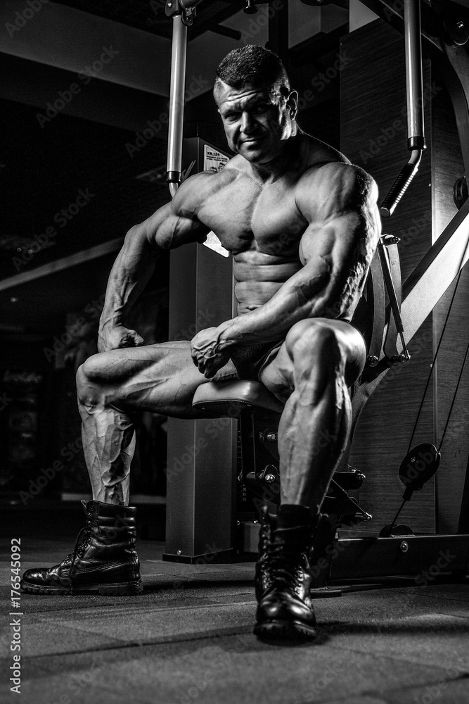 Fototapeta Brutal Caucasian bodybuilder working out in gym