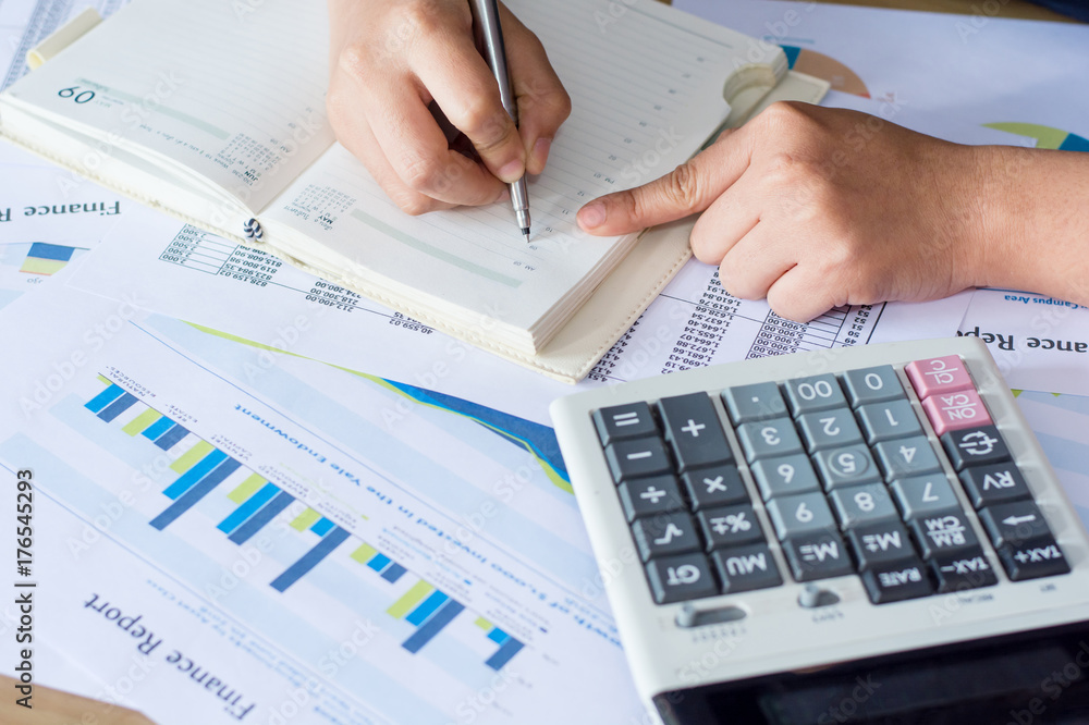 Business concep : close up woman hand using calculator and writing make note with calculate at office desk. Business concep : close up woman hand using calculator and writing make note with calculate at office desk.