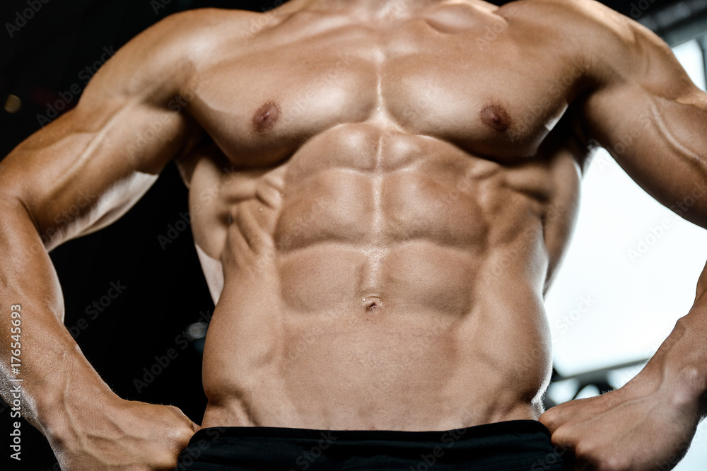 Handsome model young man training abs in gym Handsome model young man training abs in gym