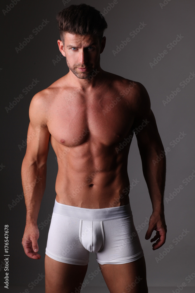 Young well build man is posing in white underpants.