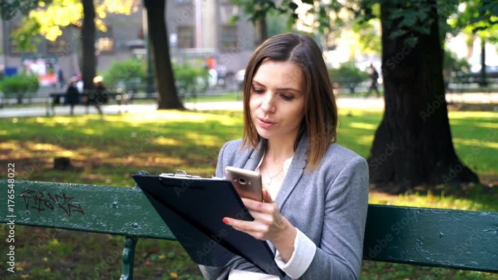 Businesswoman comparing documents with smartphone on the bench in the city
Businesswoman comparing documents with smartphone on the bench in the city