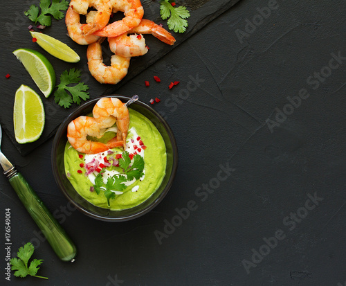 Delicate avocado soup with shrimps, lime and cilantro.