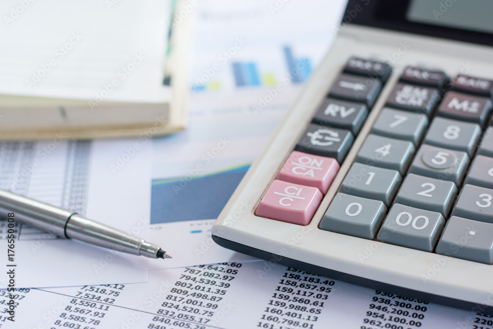 Close up pen on finance report and calculator on table office. Close up pen on finance report and calculator on table office.