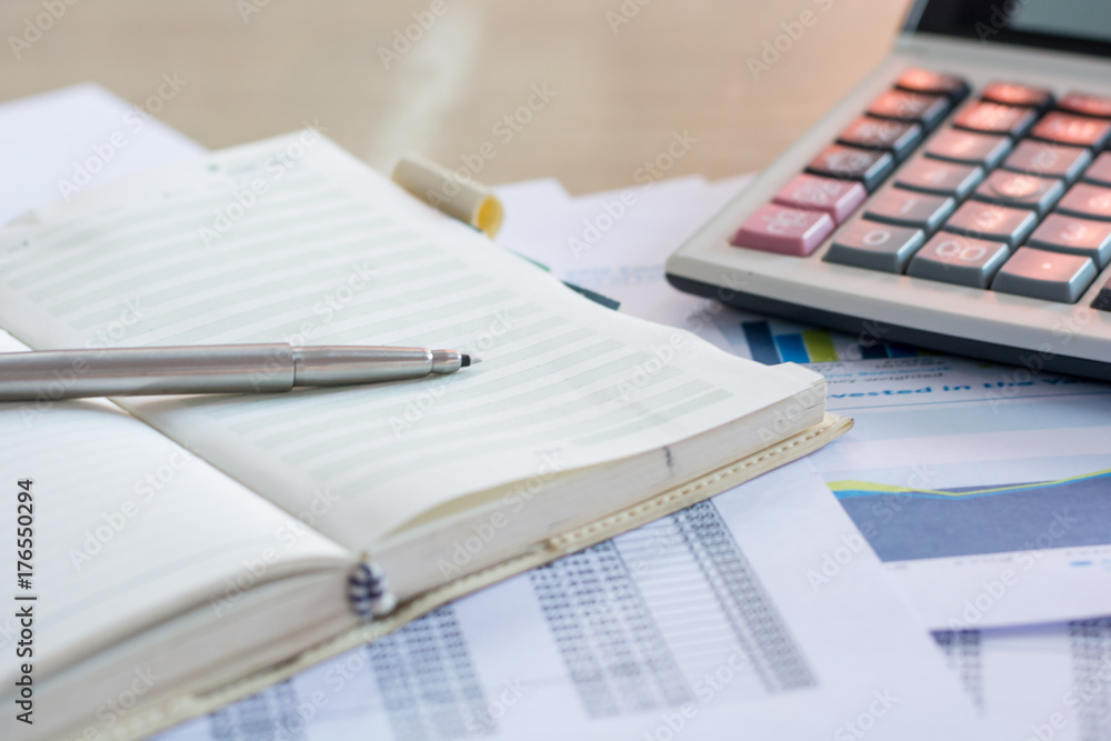Close up pen on finance report and calculator on table office. Close up pen on finance report and calculator on table office.