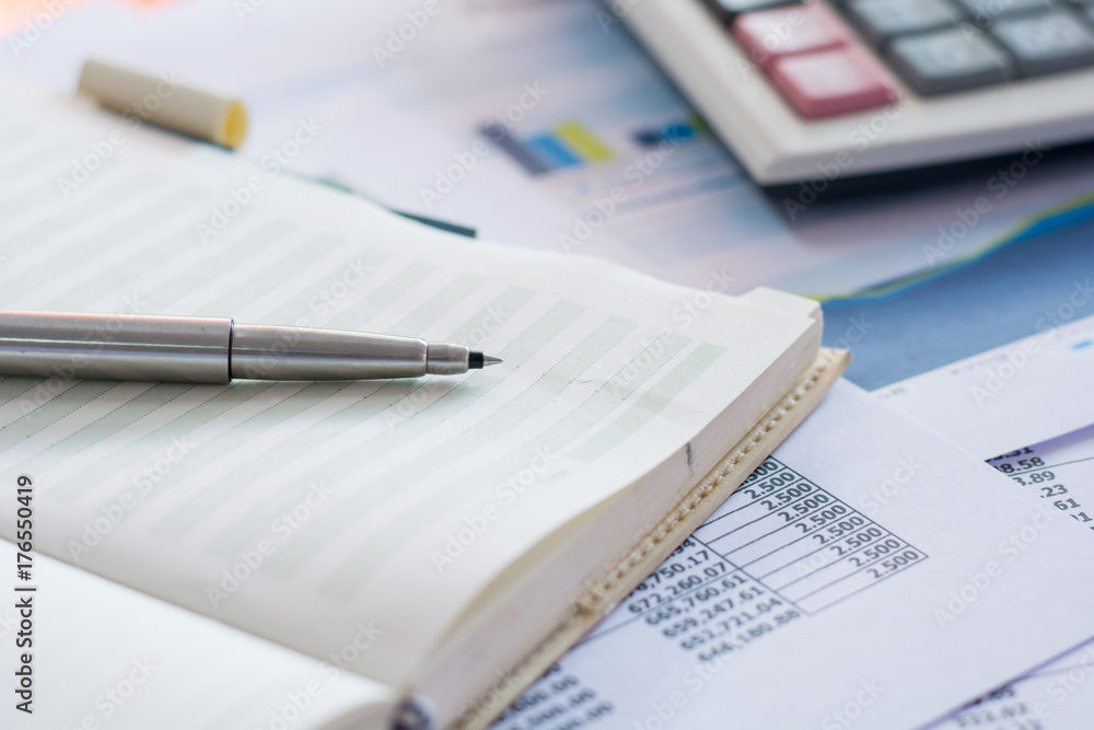 Close up pen on finance report and calculator on table office. Close up pen on finance report and calculator on table office.