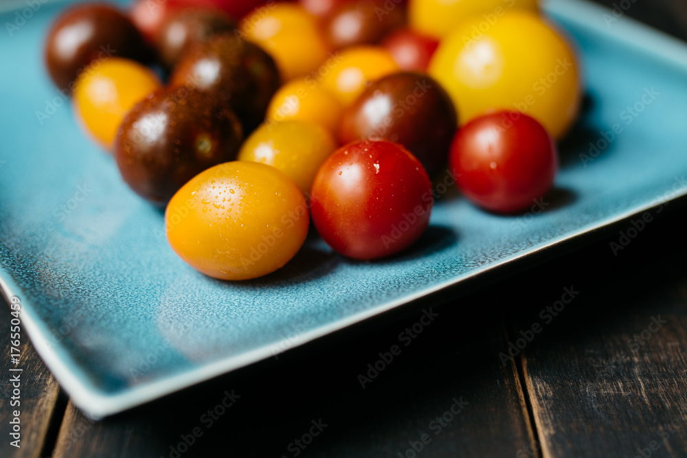 Colorful tomatoes on a ceramic turquoise plate Colorful tomatoes on a ceramic turquoise plate