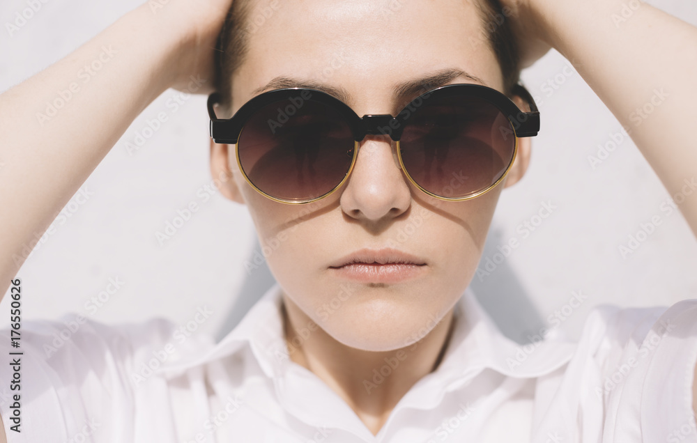 portrait of young woman with short hair and round sunglasses . portrait of young woman with short hair and round sunglasses .